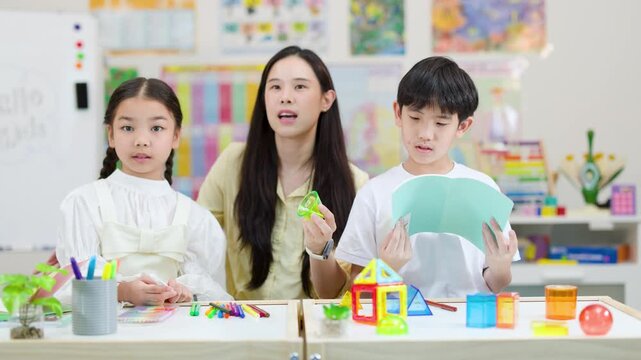 Teacher Guiding Children Through Creative Classroom Learning Activity