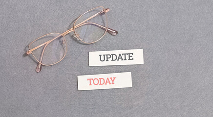 A thoughtful composition featuring elegant reading glasses beside 'UPDATE' and 'TODAY' text blocks, symbolizing the daily commitment to staying informed and current