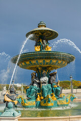 At Place de la Concorde in Paris, France, the Fontaine des Fleuves rises in gilded form. Sculpted river figures crown the basin as arcs. Historic grandeur fills square.