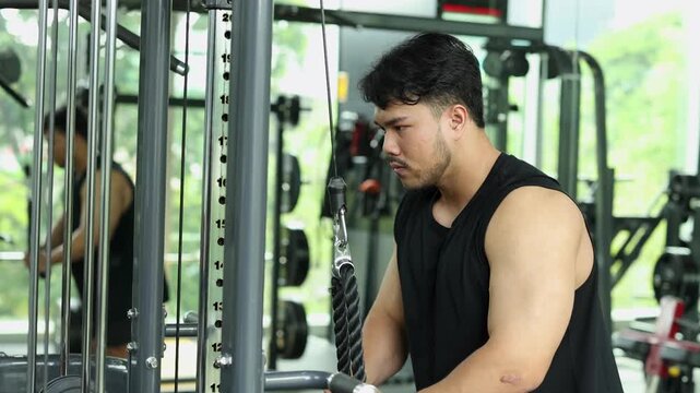 Man Performing Tricep Rope Pushdowns in Gym
