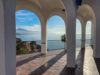 Scenic white arches on the Balcón de Europa promenade framing a stunning view of Mediterranean Sea...