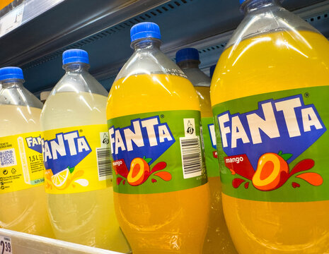 Villach, Austria - December 13, 2025: Fanta soda bottles in vibrant colors displayed on supermarket shelf, showcasing mango and lemon flavors with eye-catching branding and packaging design