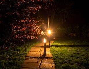 Illuminated stone path under flowering tree in a night garden