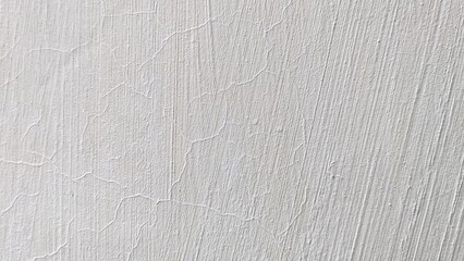 White cracked concrete wall background texture with visible brush strokes and aged plaster architectural surface.