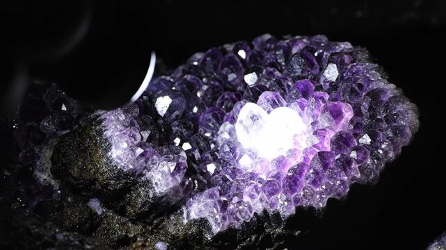 Macro shot of sparkling amethyst geode with intense purple crystals, Detailed view of a luminous amethyst cluster illuminated from within