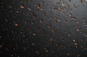 Fototapeta premium Dark texture with scattered crumbs and small white specs. Close-up view shows rough surface detail, suitable for grunge or abstract backdrops. Great for food-related or gritty themes.