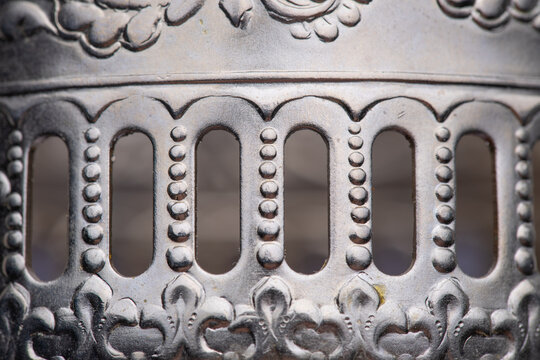 Close-up of details of a Soviet-era tea glass holder with handle featuring a floral pattern