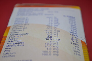 Supplement label with detailed vitamin and mineral values on orange white layout highlighting nutrient transparency for health product marketing and educational nutrition visuals