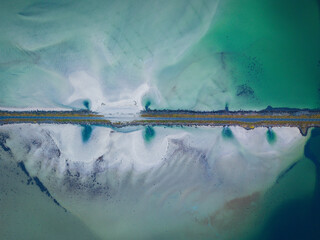 Top-Down Aerial View of a Coastal Road Cutting Through Turquoise and Sandy Waters