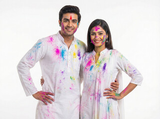 colorful holi celebration with young indian couple covered in festival colors isolated on white background for seasonal creatives