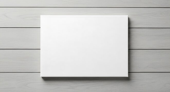 Blank white canvas mockup resting on a rustic light gray wooden plank surface, ideal for showcasing designs, art, or product displays