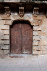 Fototapeta premium Old wooden door set in a stone wall.. City of Siguenza in Spain