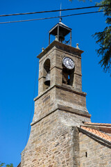 Obraz premium Stone clock tower against a clear blue sky.