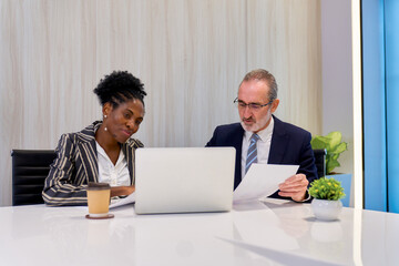Businessman in formal suit working with his secretary businesswoman in meeting room for summary document with laptop , Co-working space concept.