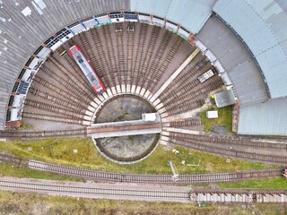 Obraz premium Aerial Top View of Railway Roundhouse with Turntable and Red Train