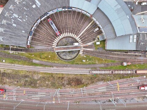 Aerial Top View of Railway Roundhouse with Turntable and Red Train