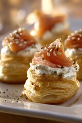 Delicious puff pastry vol au vents topped with creamy cheese, smoked salmon, and a sprinkle of sesame seeds
