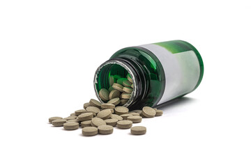 Herbal capsules spilling out of green plastic bottle, natural dietary supplements on white background