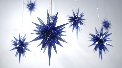 Hanging Blue Star Ornaments on Strings with Soft Lighting Against a White Background