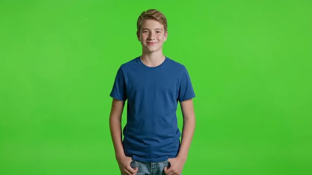 Smiling young man in blue t-shirt standing against green background