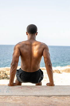 Man doing bench dips. Athletic man doing triceps dips on bench outdoors. 