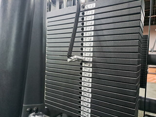 Close-up of weight plate on gym equipment. Dumbbell bar with weights on a machine in a fitness studio