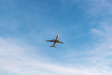 Passenger airplane flying high in clear blue sky viewed from below, minimalistic composition with large copyspace, concept of air travel, freedom, transportation, aviation and journey