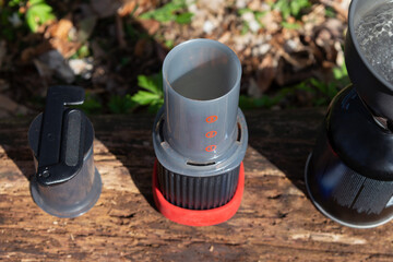 AeroPress coffee maker with plunger and camping gear prepared for outdoor manual brewing