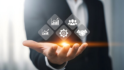 Businessman presenting glowing icons representing data analysis and strategy on his hand in a modern office setting with a blurred background