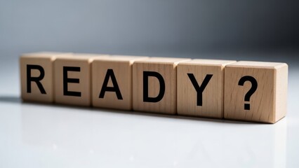 Wooden blocks spell ready question mark on white surface.