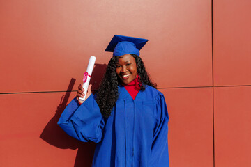 Smiling african american student celebrating university graduation with her diploma