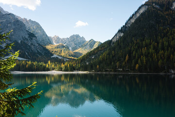 Fototapeta premium Mountain Lake Scene - Lago di Braies Italy Dolomites, Emerald green lake with mountains, alpine trees and alps landscapes - jigsaw puzzle and chocolate box perfect - sunny autumn fall day