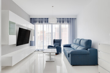 Bright modern living room with blue sofa and minimalist interior design