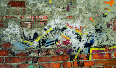 Abstract: crumbling graffiti on a city street wall. Colorful abstract background. Old, cracked, peeling paint serves as the backdrop.