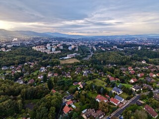 Fototapeta premium Golden Sunset Over Mountain Homes, Enchanting Sunset Bathes Hillside Houses And Winding Pathways Below