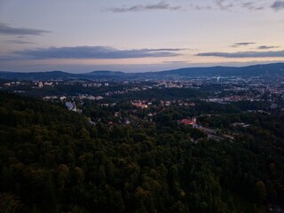 Fototapeta premium Transition From Daylight To Twilight With Silhouettes Blending Into Illuminated City Background