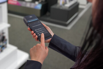 Person selecting payment method on modern portable POS terminal in retail environment, representing digital checkout interface, user interaction, and fintech payment technology