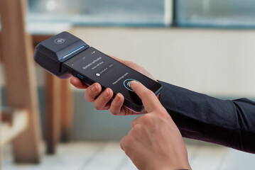 User confirming payment with biometric fingerprint verification on portable POS terminal, representing secure authentication, identity confirmation, and advanced fintech payment technology