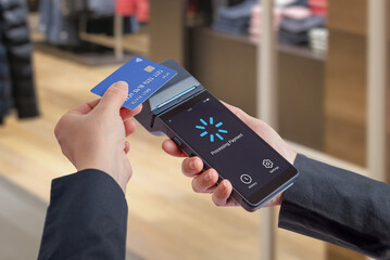 Portable POS terminal displaying payment processing interface while card is inserted, showcasing user interface design, loading state, and digital checkout workflow experience