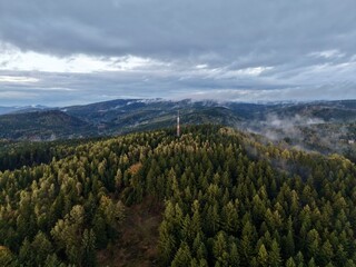 Fototapeta premium Surveillance Drone Captures Mysterious Foggy Skyline With Distant Rolling Hills And Forests