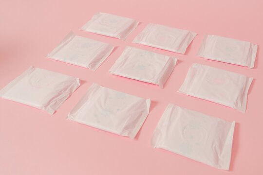 Flat layout of sanitary napkins on pink background. Menstruation cycle, feminine hygiene and protection