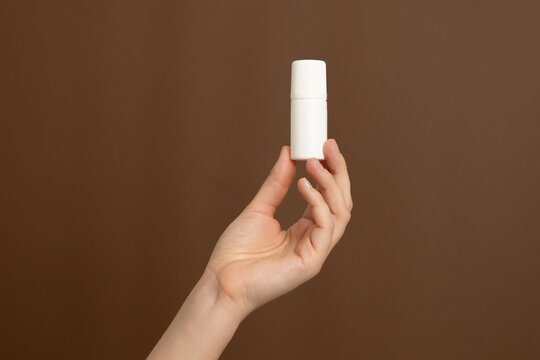 Hand holding blank white cosmetic or medicine roll-on bottle