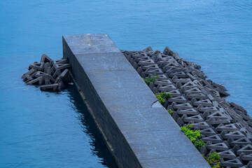 静かな青い海と防波堤の風景