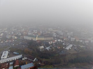 Fototapeta premium Misty Neighborhood Scenery, Serene Morning Landscape Featuring Foggy Streets And Reflective Waters