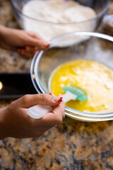 Step-by-step homemade chocolate chip cookie baking process, showing mixing wet and dry ingredients, folding in chocolate chips, and scooping raw cookie dough onto a baking sheet in a home kitchen. 