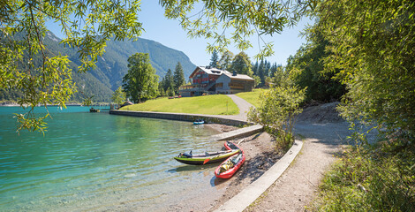 Excursion destination Gaisalm on Lake Achensee, two kayaks on the shore, framed by willow branches. © SusaZoom