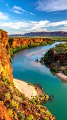 Serpentine river flowing through a canyon, reflecting the blue sky and surrounded by red rocks and greenery