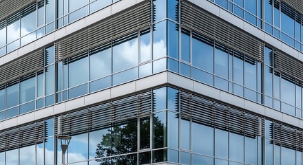 Modern glass facade reflects sky and trees with horizontal louvers.