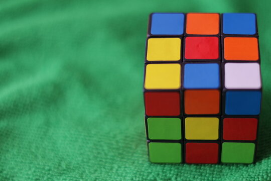 Caracas, Venezuela- 13 de julio 2025: Una toma de cerca de un cubo de rubik, con el estado sin resolver sobre un fondo verde
