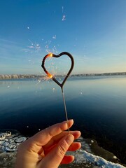 hand holding a heart sparkler for a happy new year
